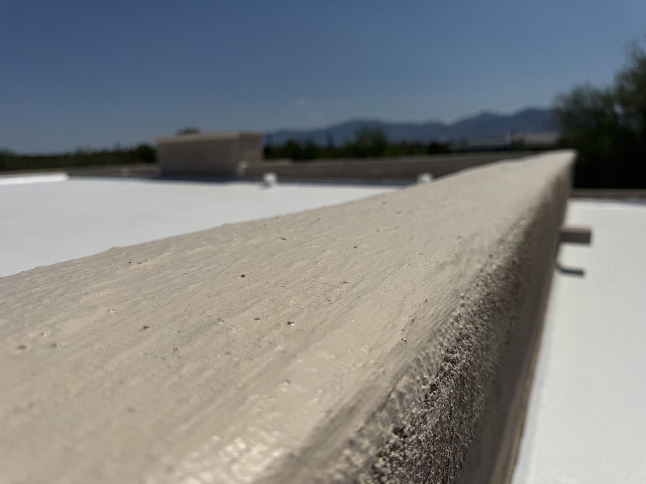 Finished parapet cap edge with roof coating
