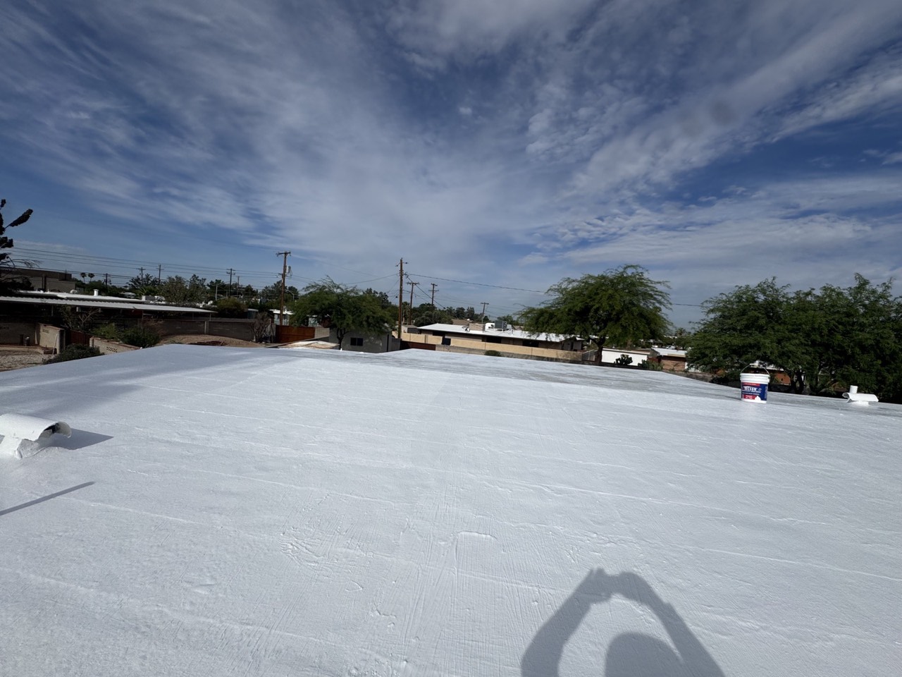 Fresh elastomeric-style roof coating under clear Tucson skies